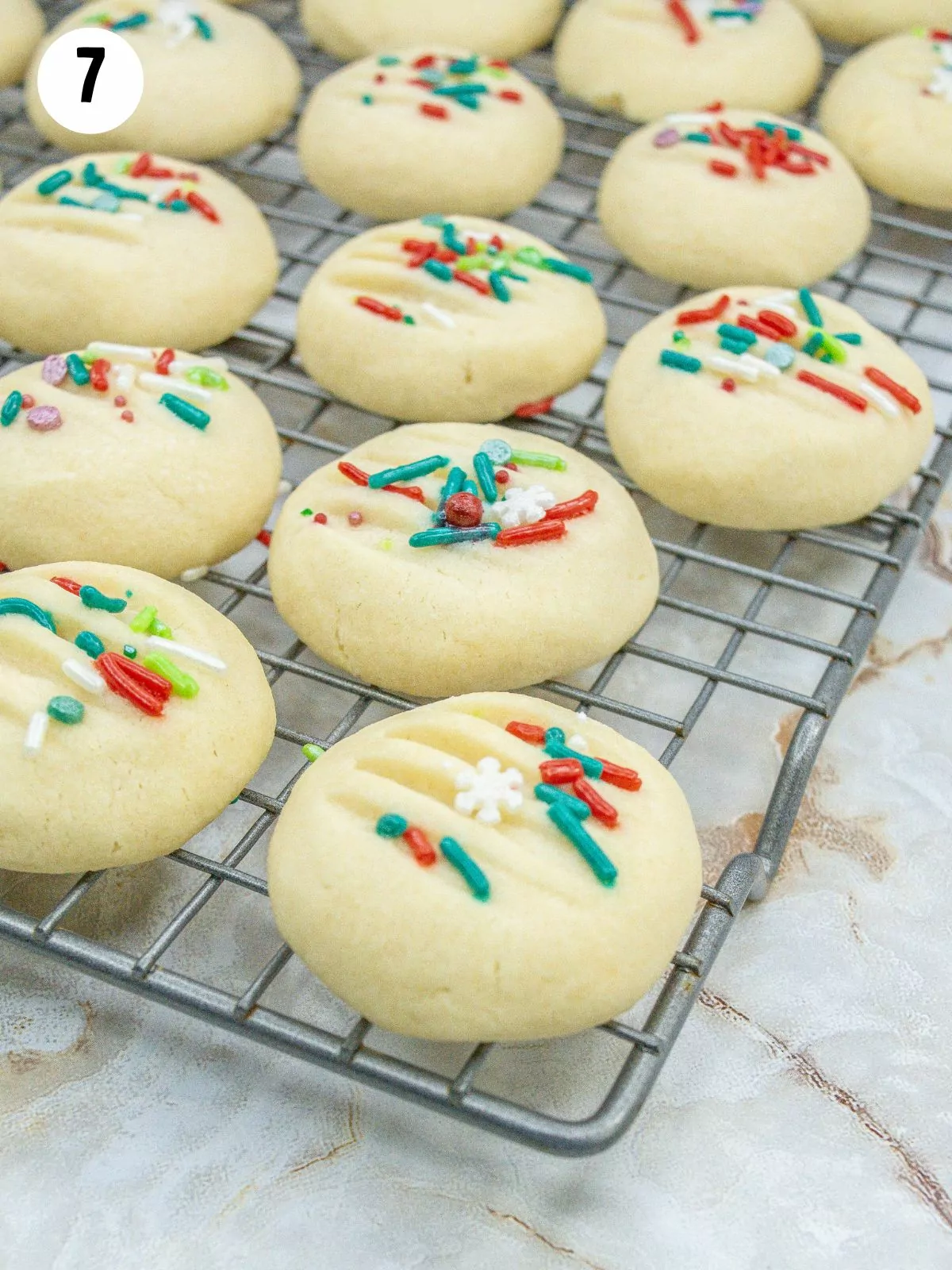 shortbread cookies with sprinkles on a cooling rack.