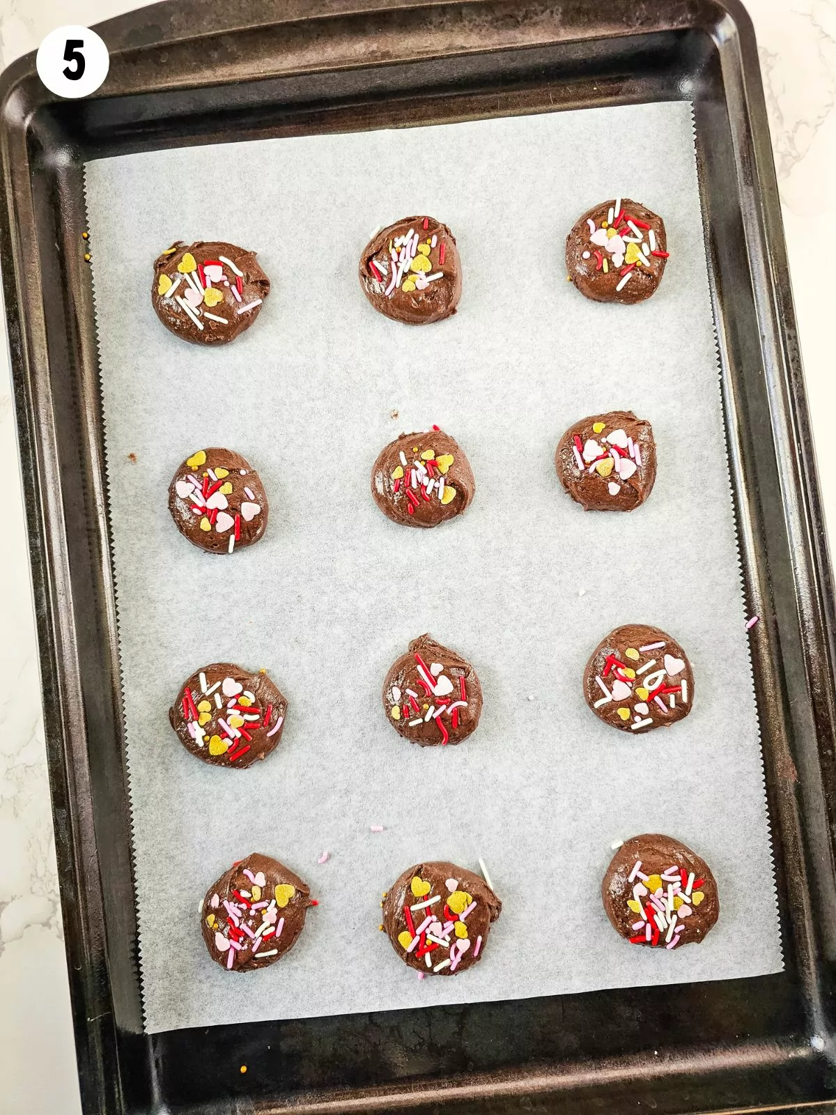 chocolate cake mix cookies on baking tray with parchment paper.