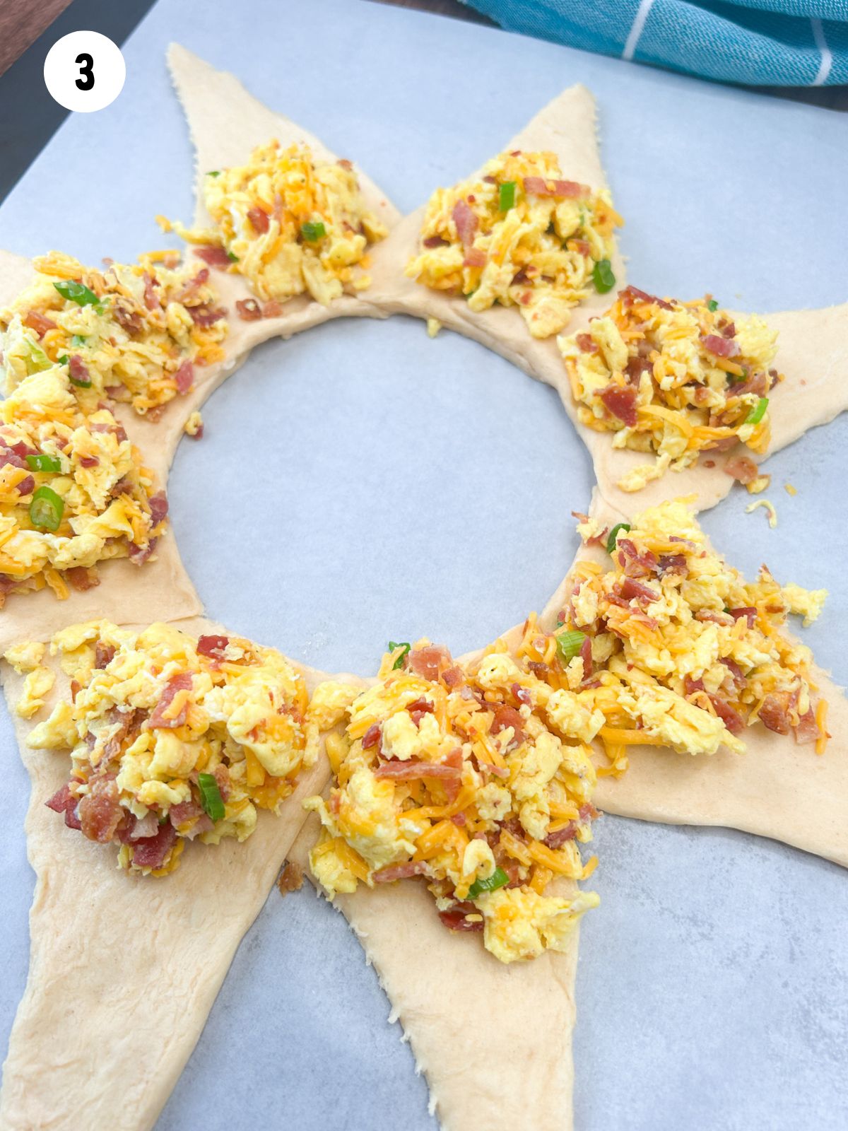 crescent roll triangles arranged in a circle with egg mixture.