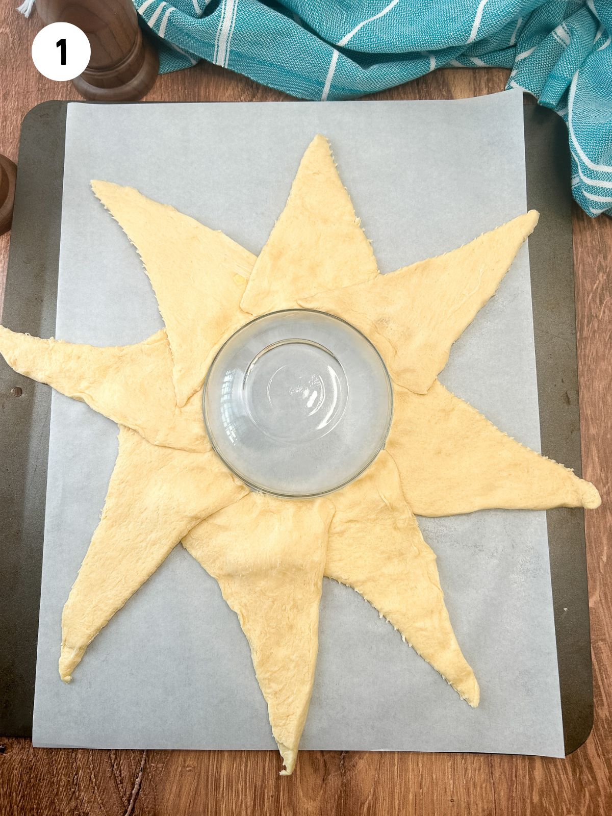 refrigerator dough crescent rolls arranged in a circle on baking sheet with bowl in the center.
