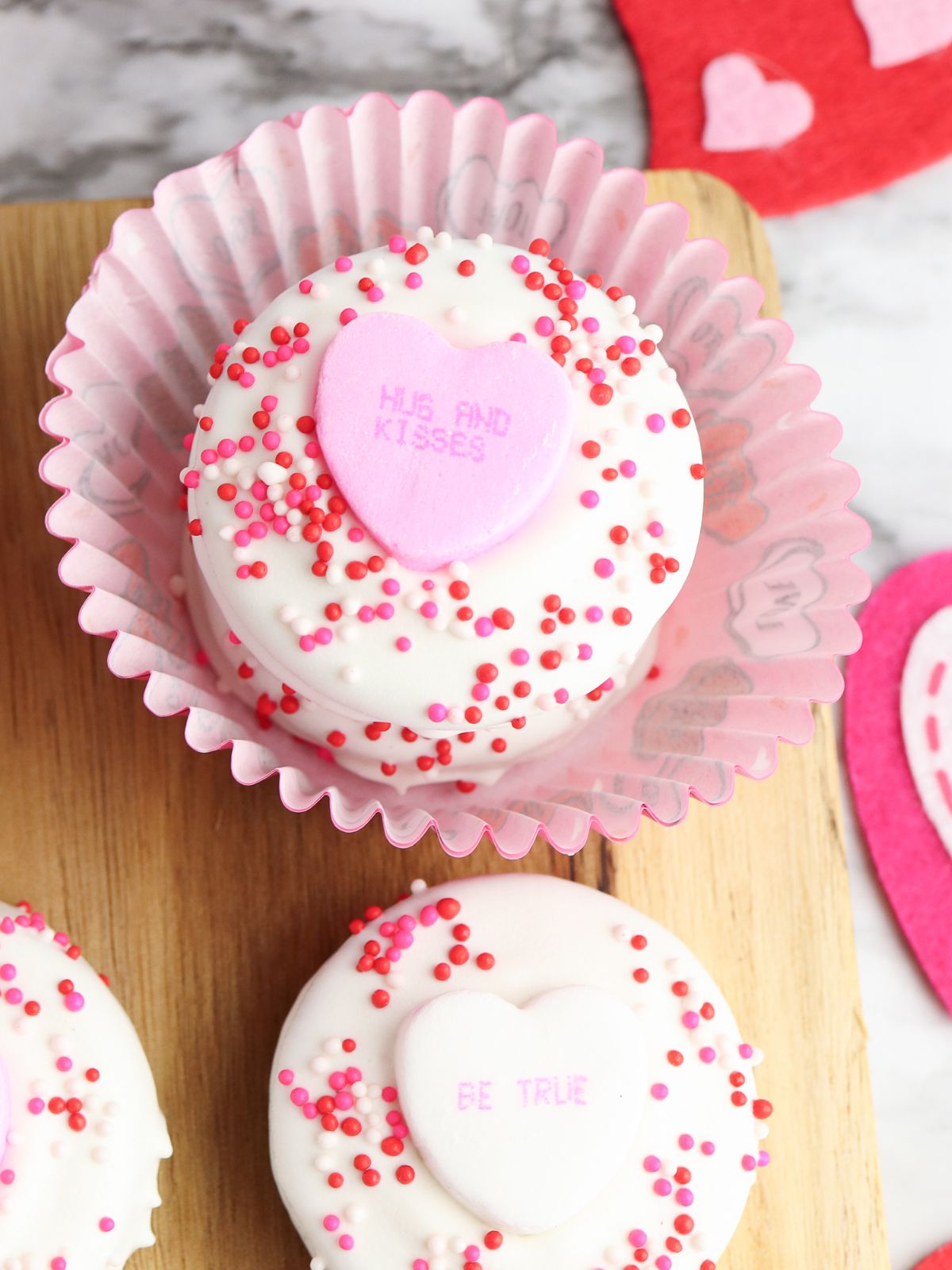 white chocolate Oreos on cutting board with one in cupcake liners.