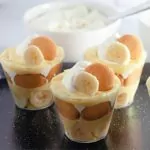 banana pudding cups on black tray.