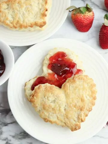 Valentine's Day biscuits on plate with jam and strawberries.