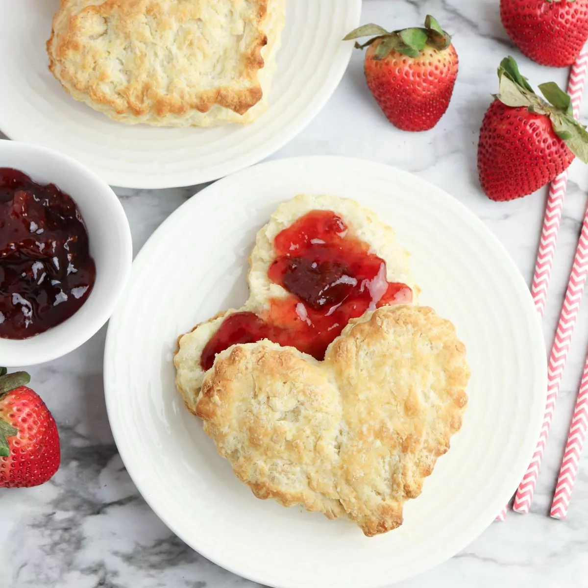 Valentine's Day biscuits on plate with jam and strawberries.