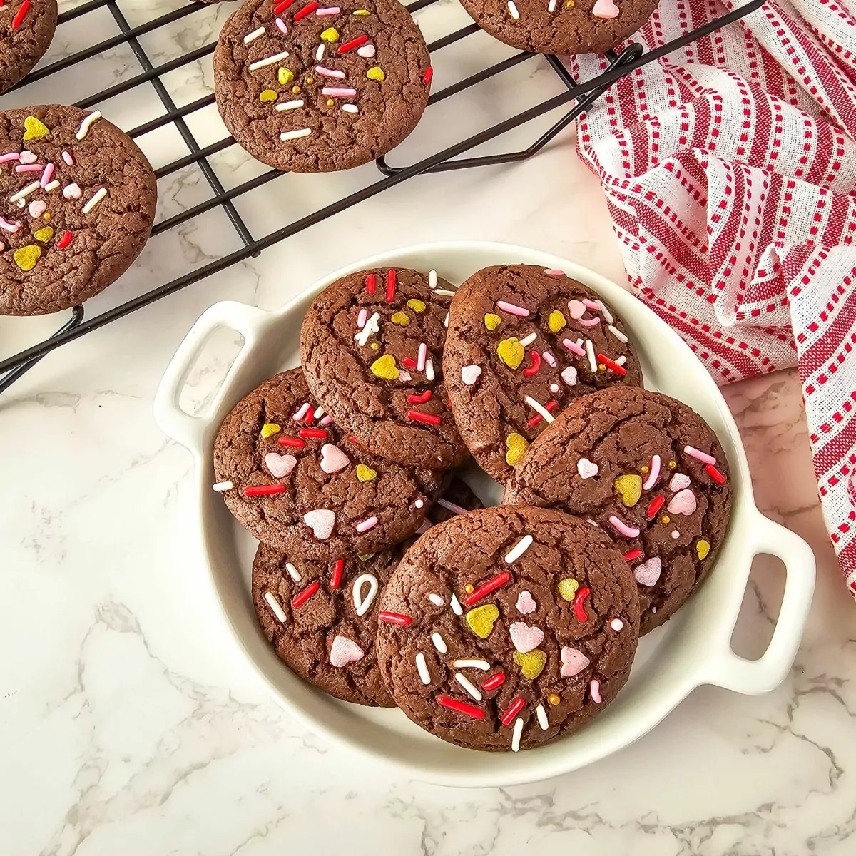 Cake mix cookies in white bowl with red stripe kitchen towel.