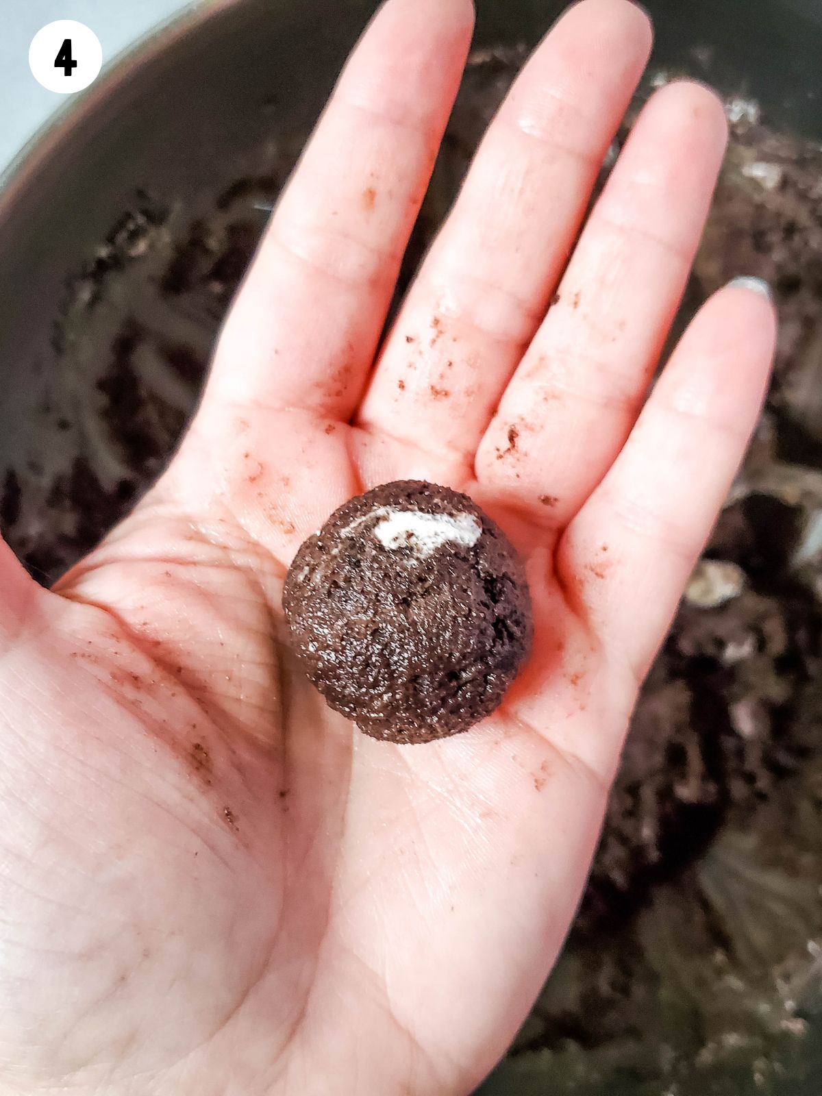 one Oreo cream cheese truffle being held in hand.