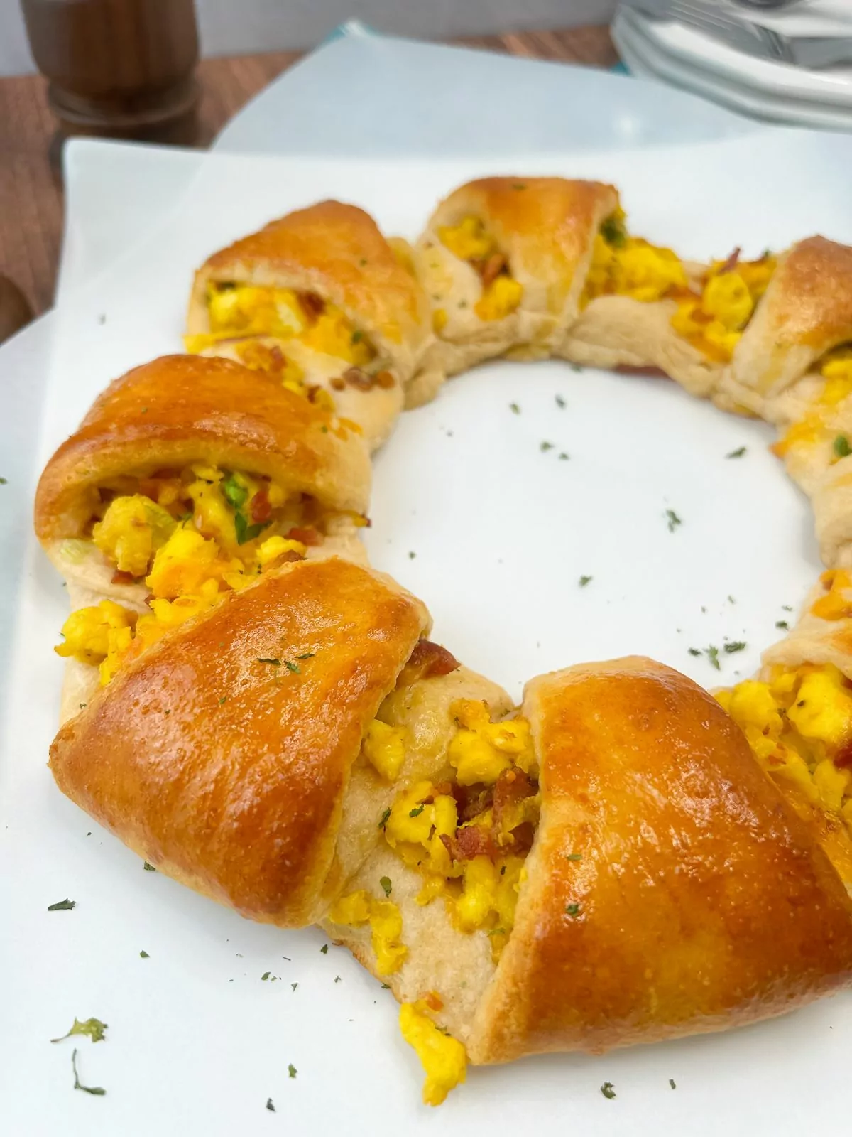 baked crescent roll wreath with scrambled eggs and bacon.