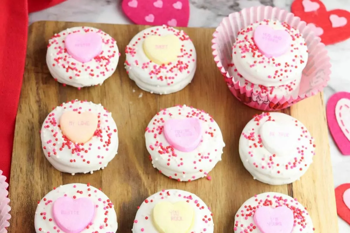 Cookies dipped in white chocolate and decorated with sprinkles and heart-shaped candies.