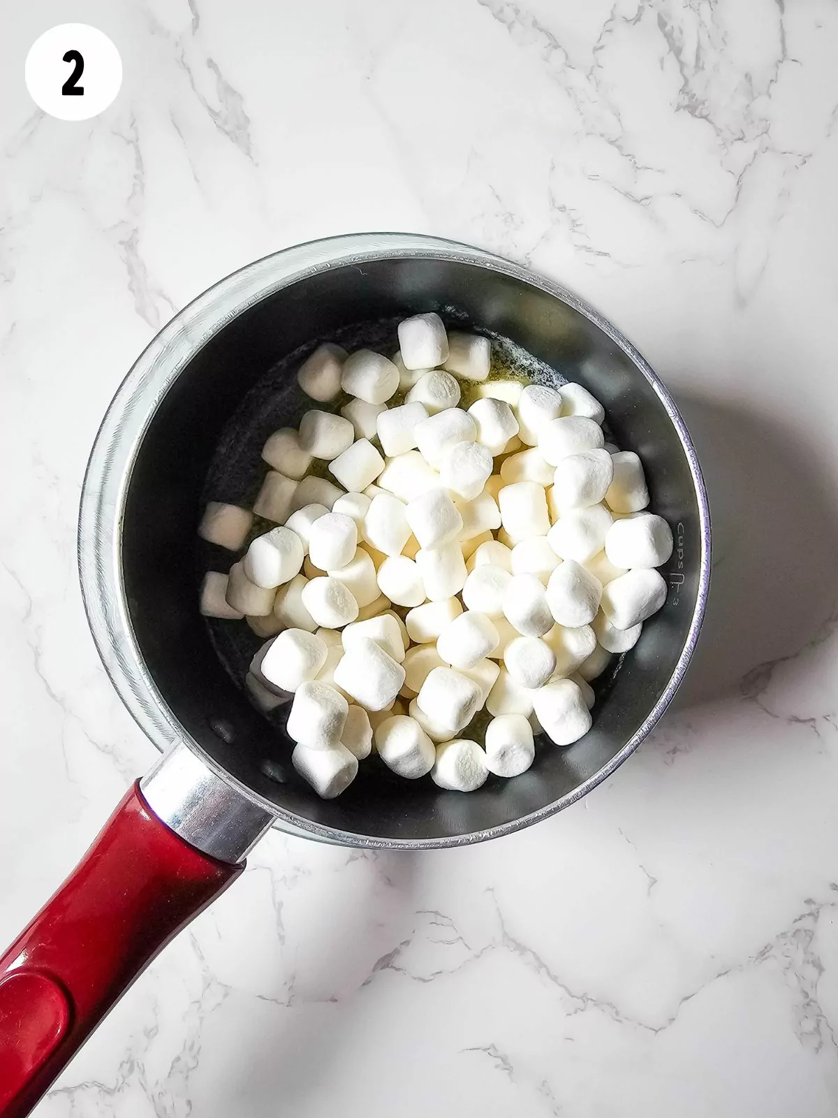 Mini marshmallows in saucepan with melted butter.