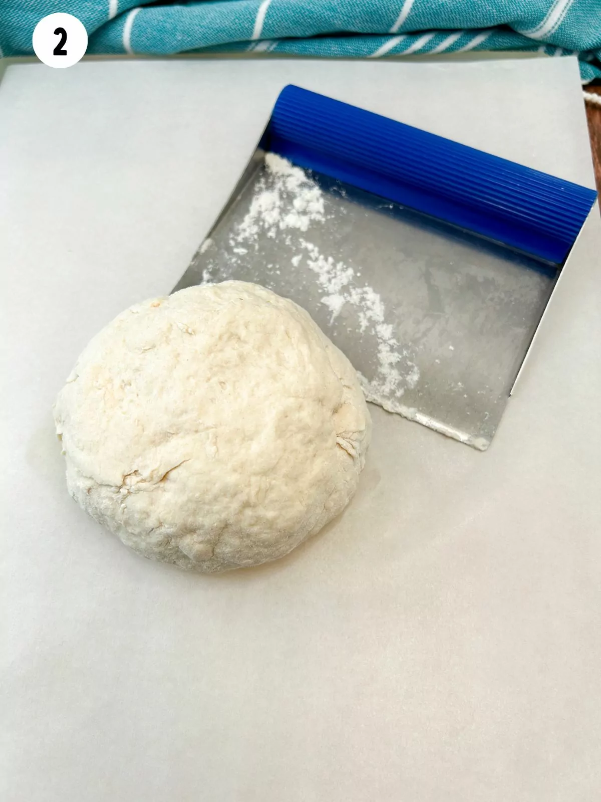 2 ingredient yogurt dough on cutting board with dough scraper.