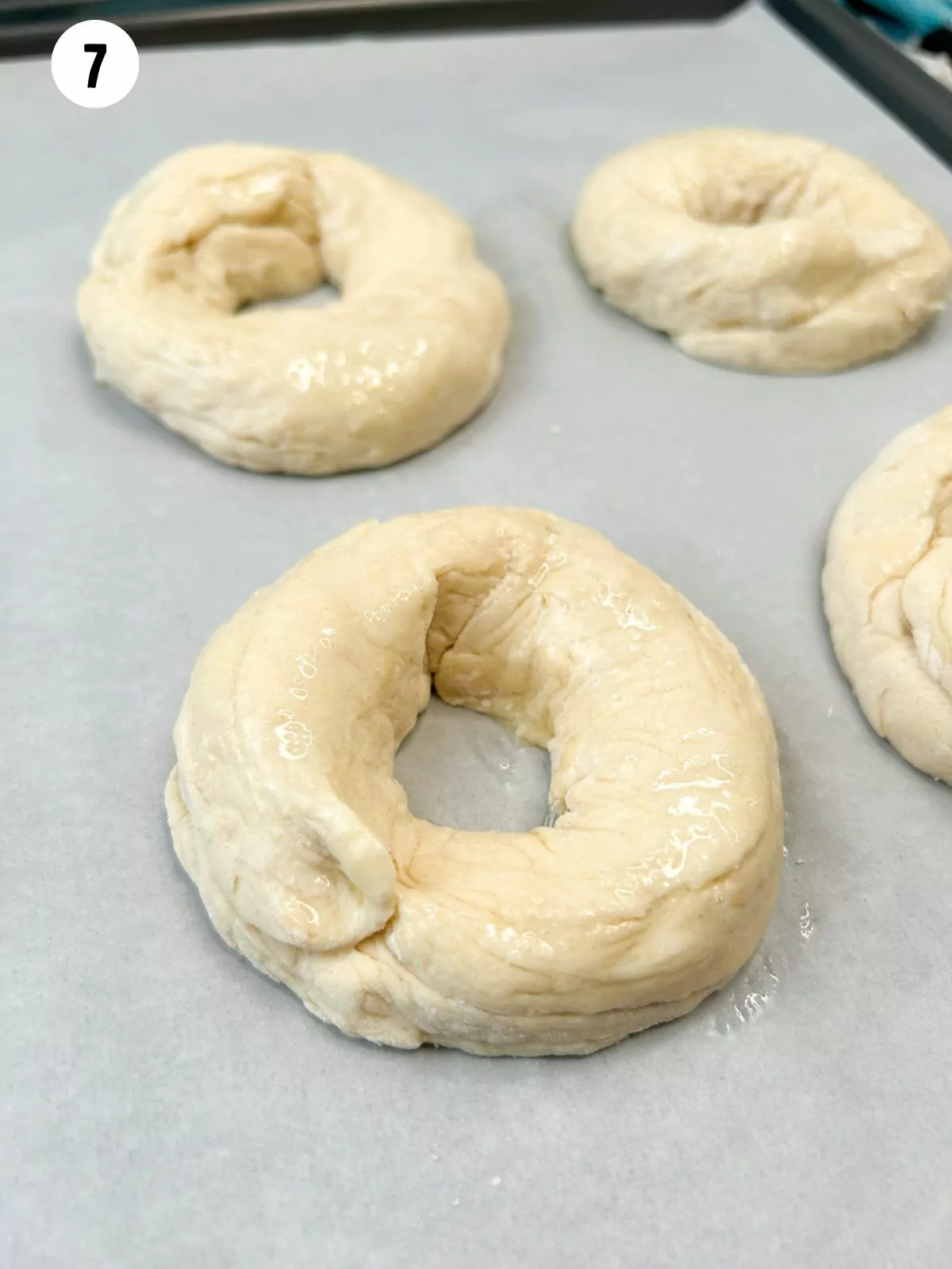 2 ingredient dough bagels on tray with parchment paper brushed with egg wash.