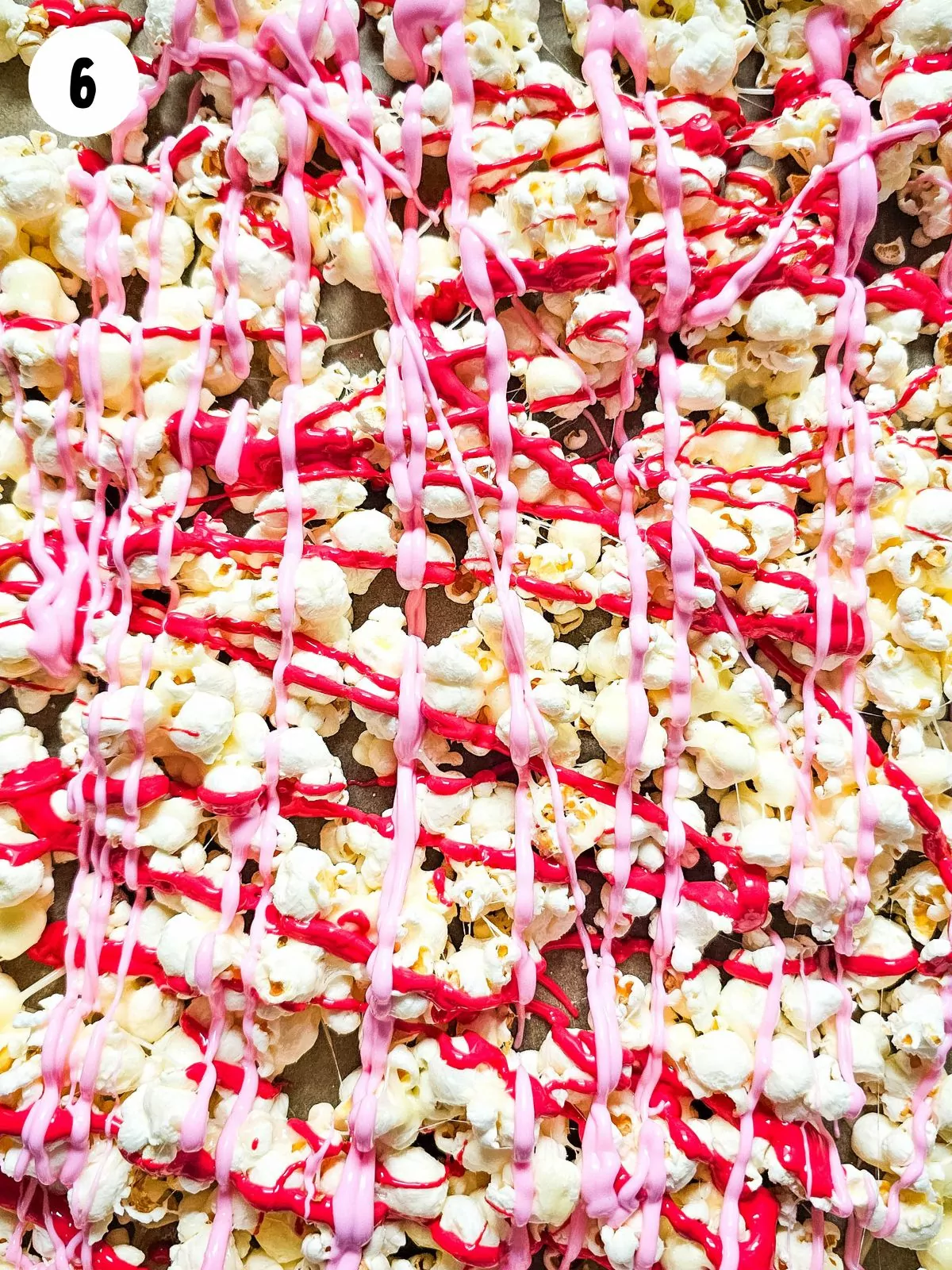 drizzle melted pink candy on top of popcorn.