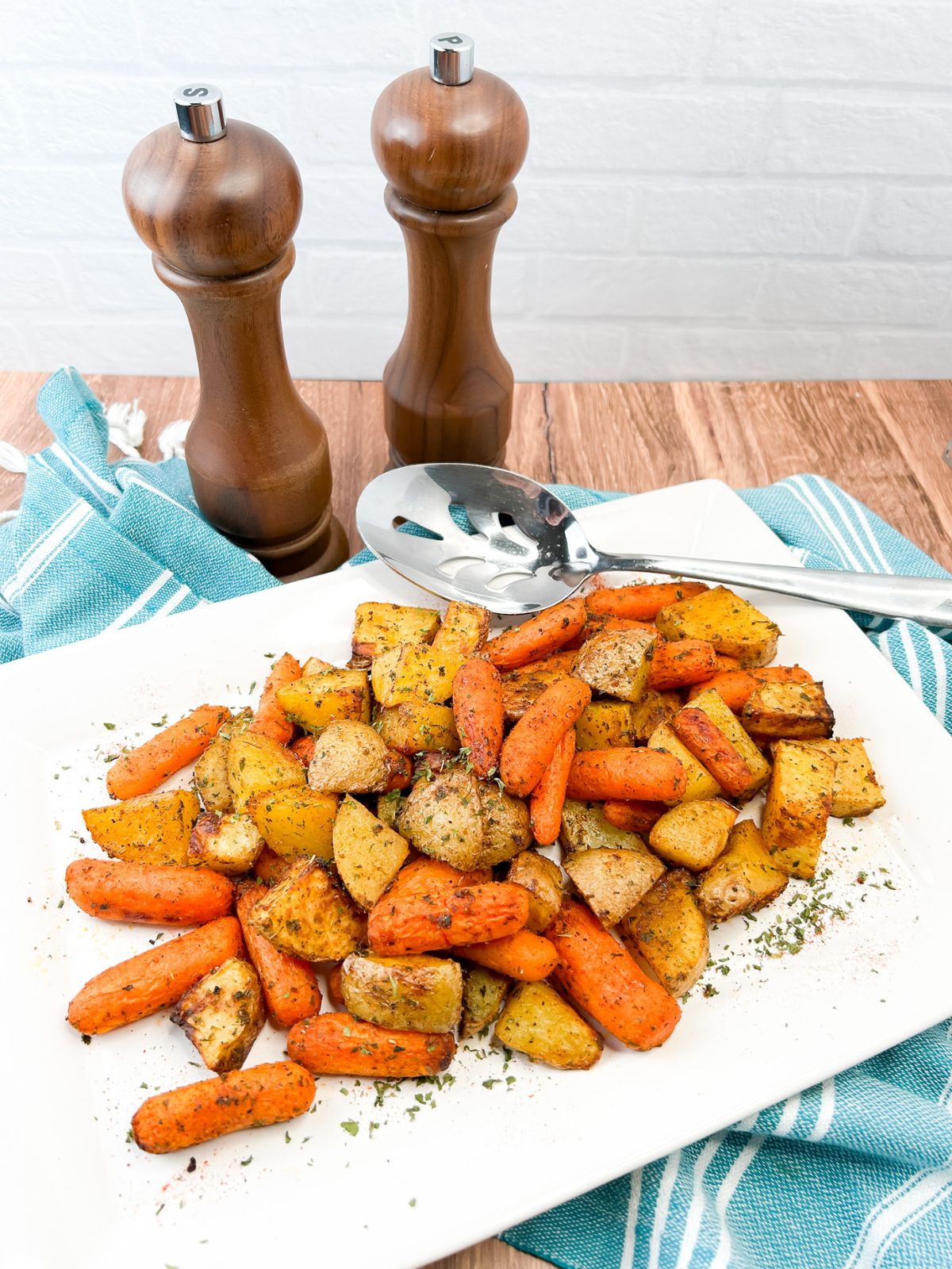air fryer vegetables served on white platter with salt and pepper containers in background.