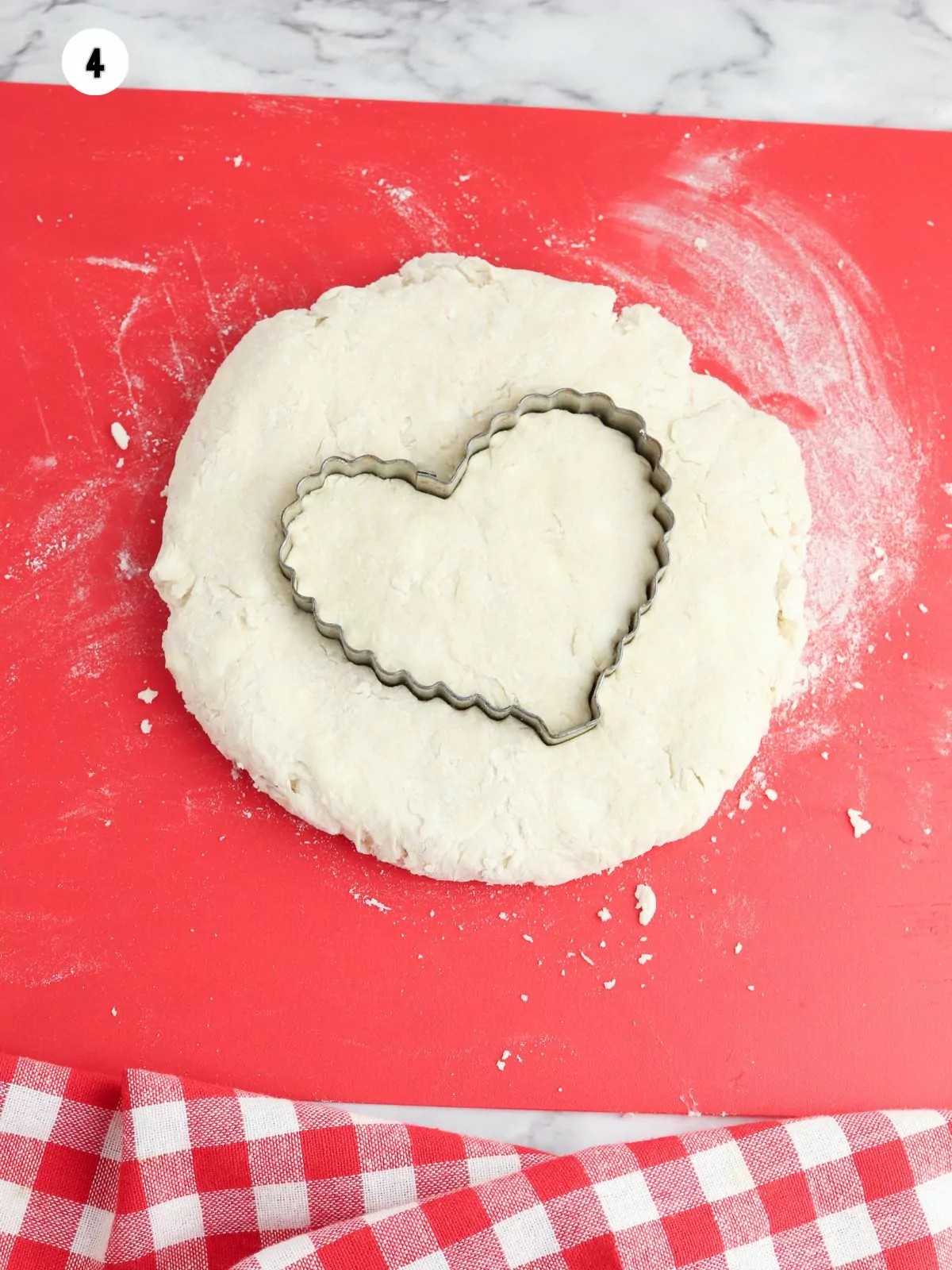 rolled out biscuit dough with heart shaped cookie cutter.