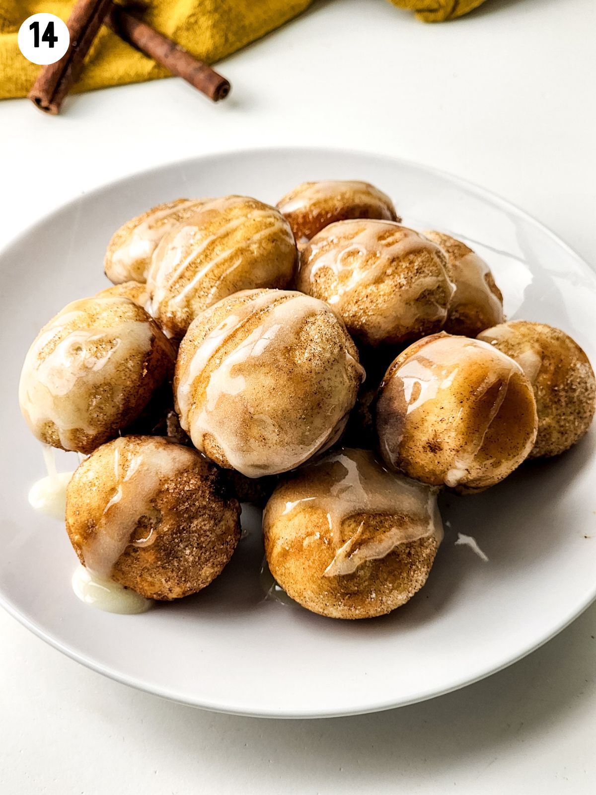 cinnamon roll balls with glaze on plate.