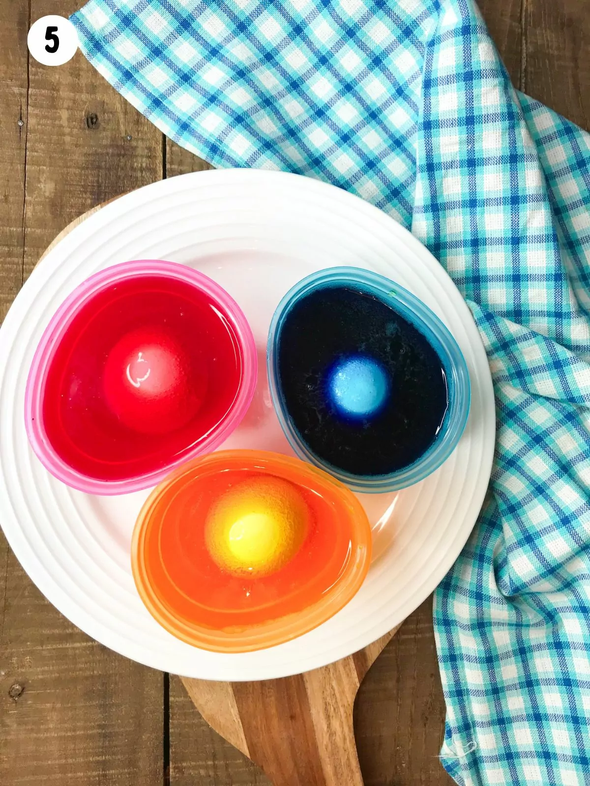 eggs in bowls of food coloring.