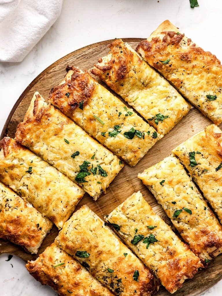 Pillsbury Pizza Dough Cheese Sticks on a round wood cutting board