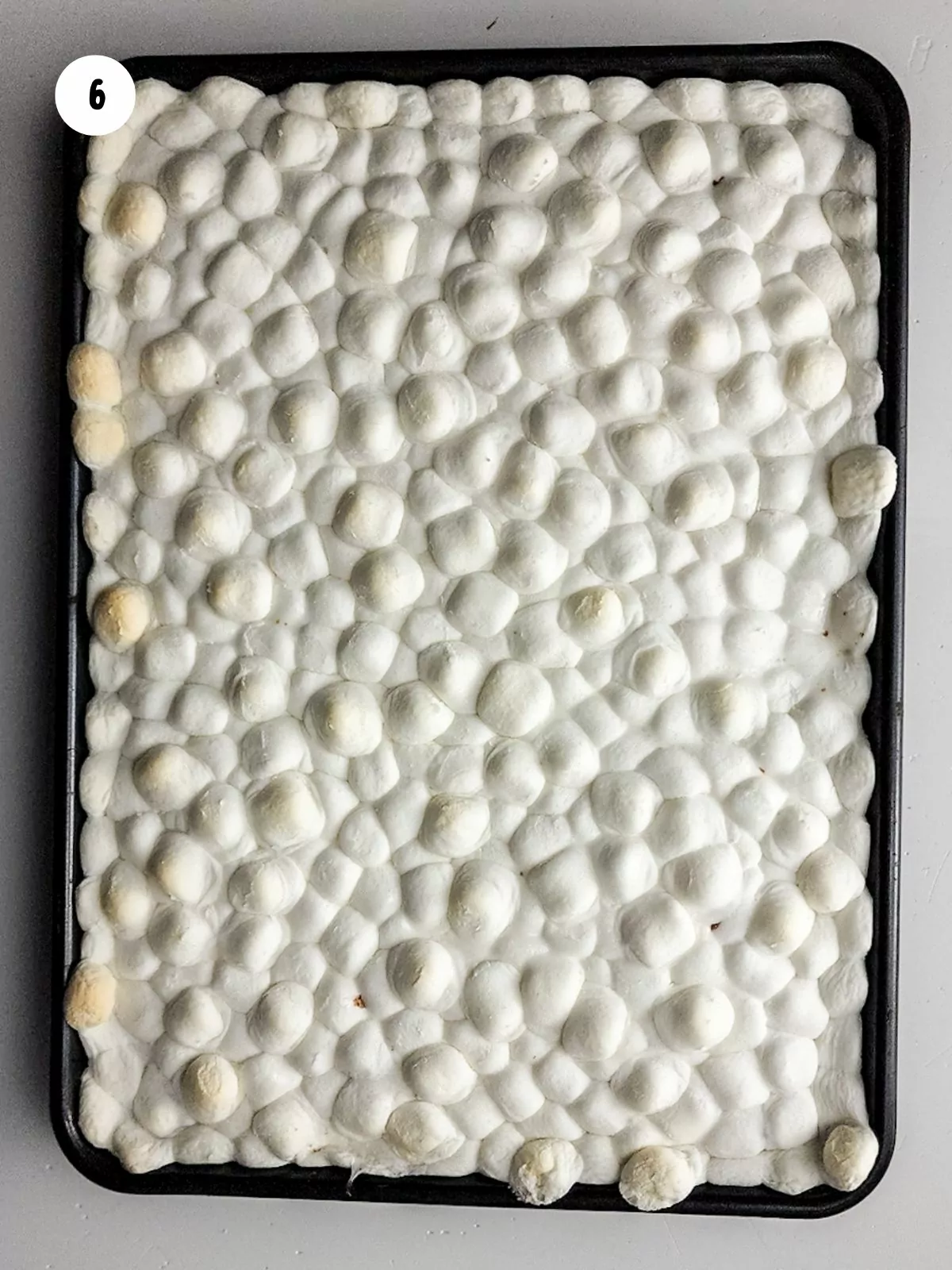 marshmallows baked on top of baked brownies in pan.