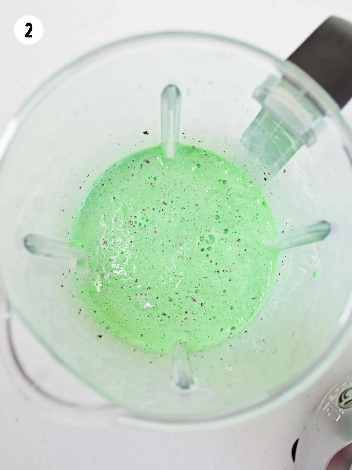 ice cream in blender with milk and green food coloring.