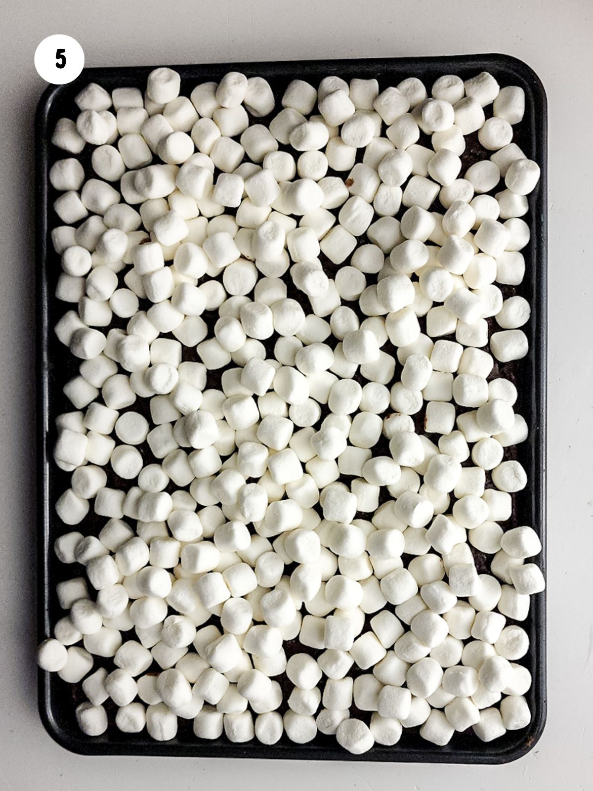 Mini marshmallows on top of baked brownies.