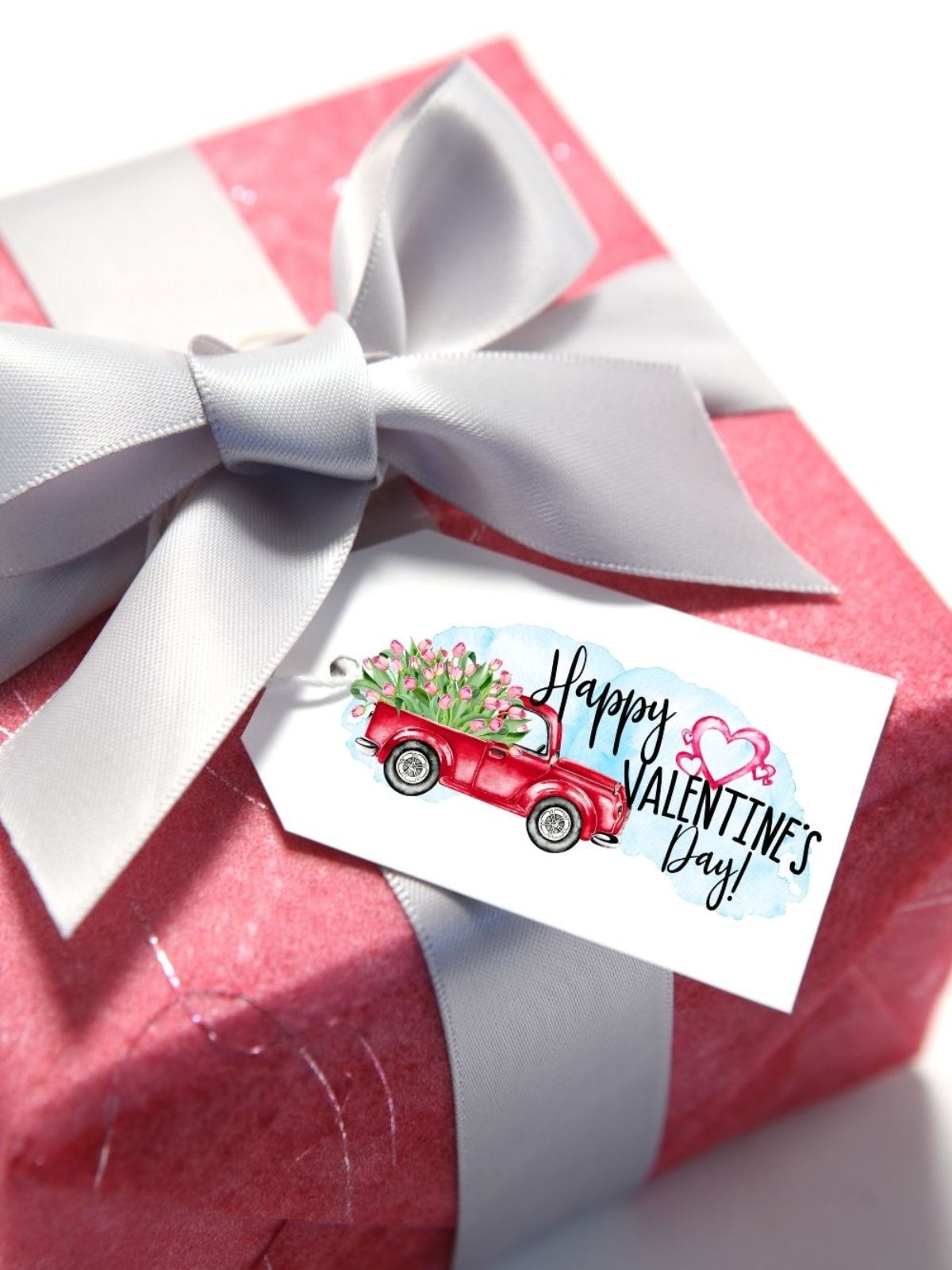 red truck with flowers gift tag on red box with bow.