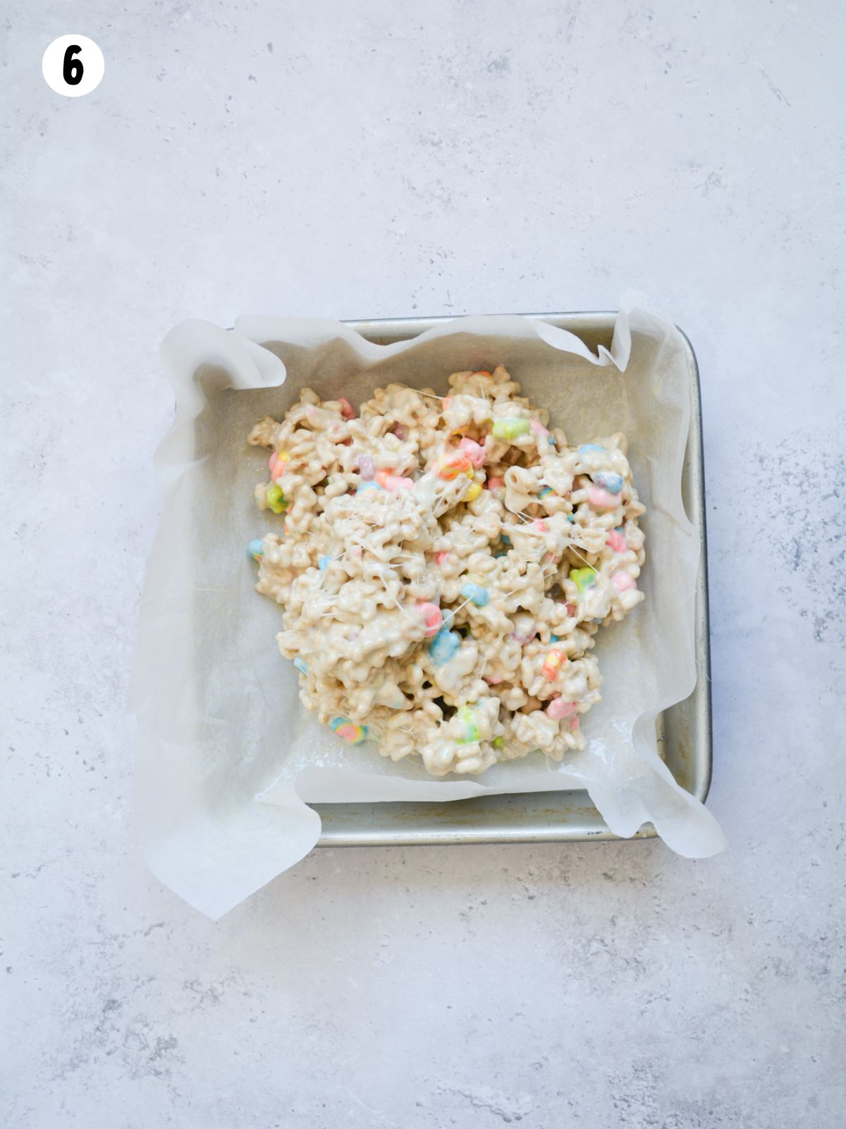 marshmallow cereal bar mixture in small pan with parchment paper.