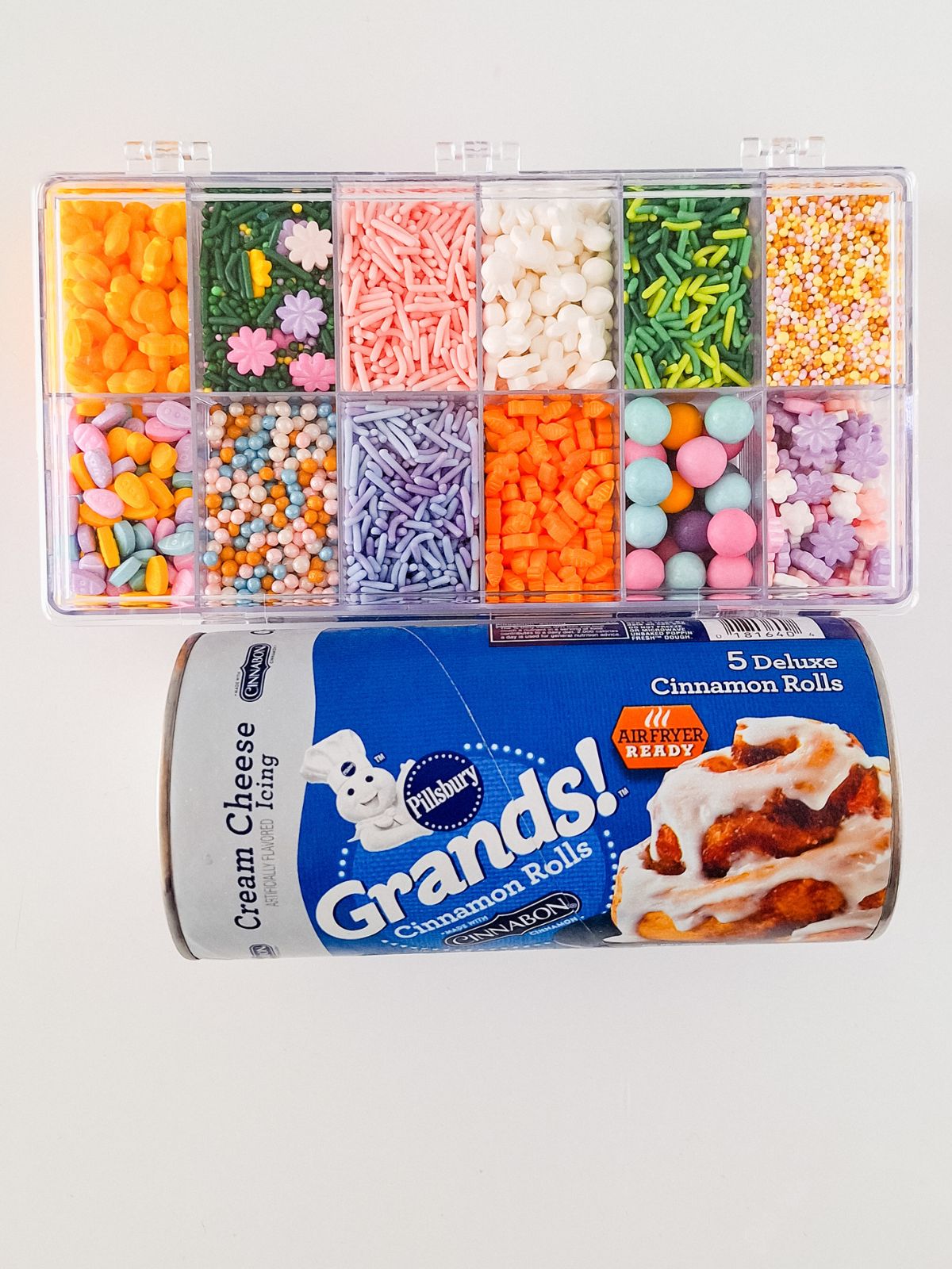 Refrigerator cinnamon rolls and container of assorted sprinkles..
