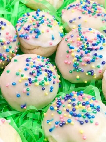 Cookies covered in white icing and colorful sprinkles