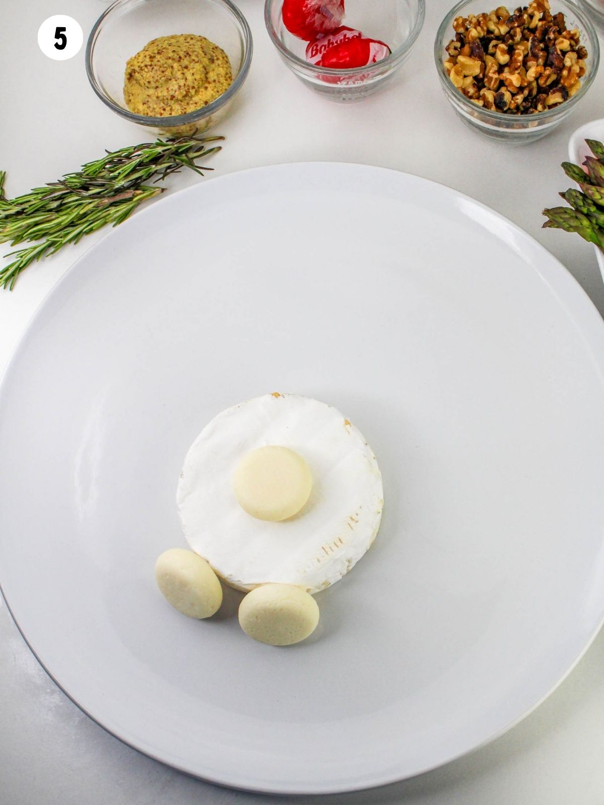 add Baby Bell cheese rounds to brie cheese for feet of bunny.