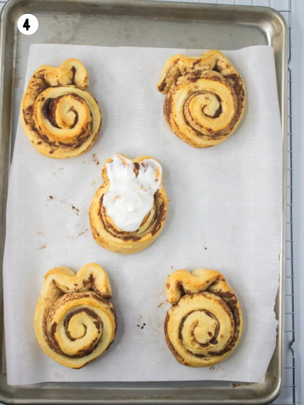 One frosted cinnamon roll and 4 unfrosted.