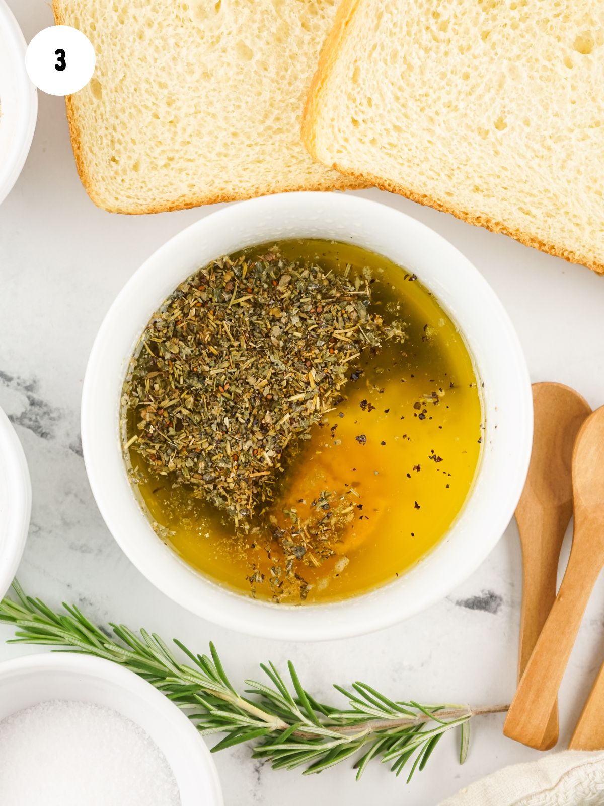 white bowl with melted butter and herbs.