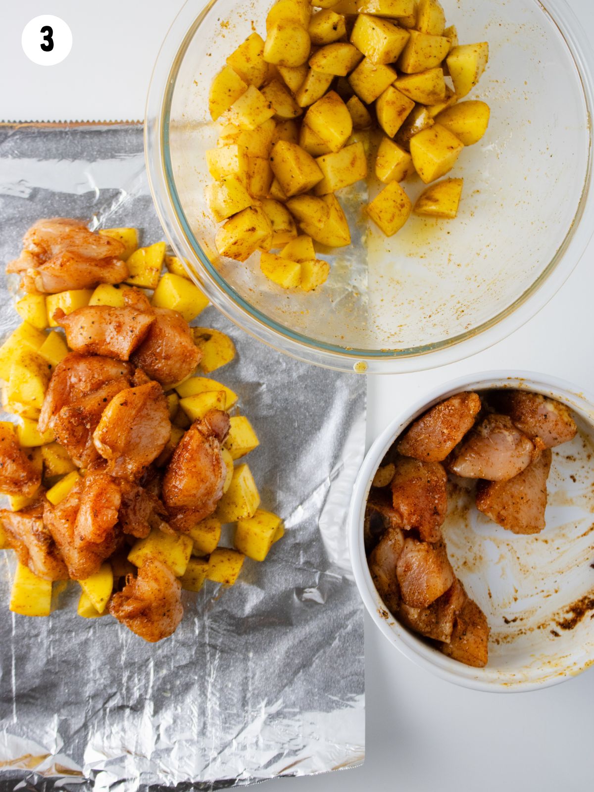 potatoes chicken in bowls and on top of aluminum foil.