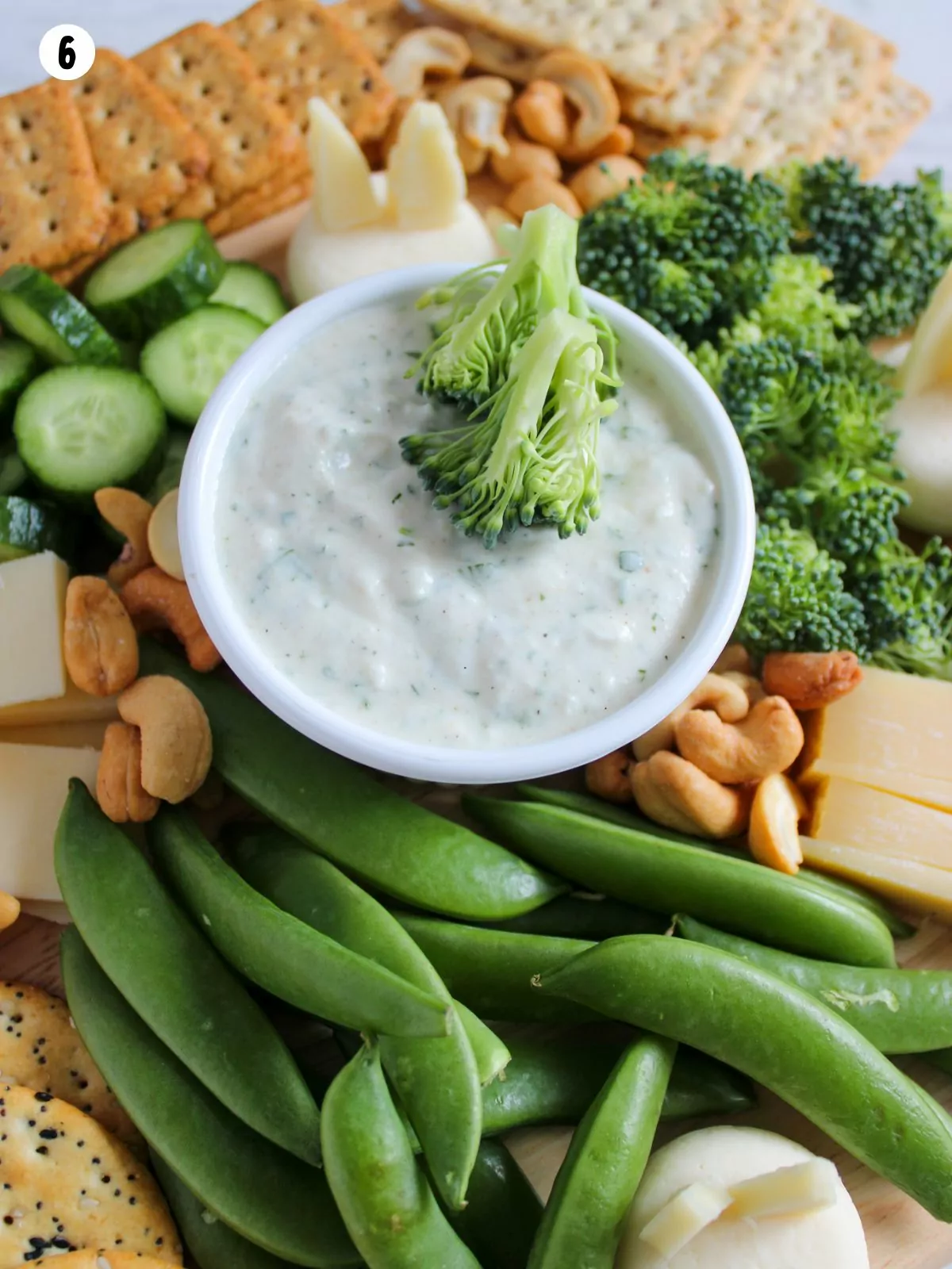 piece of broccoli being dipped in ranch dip.