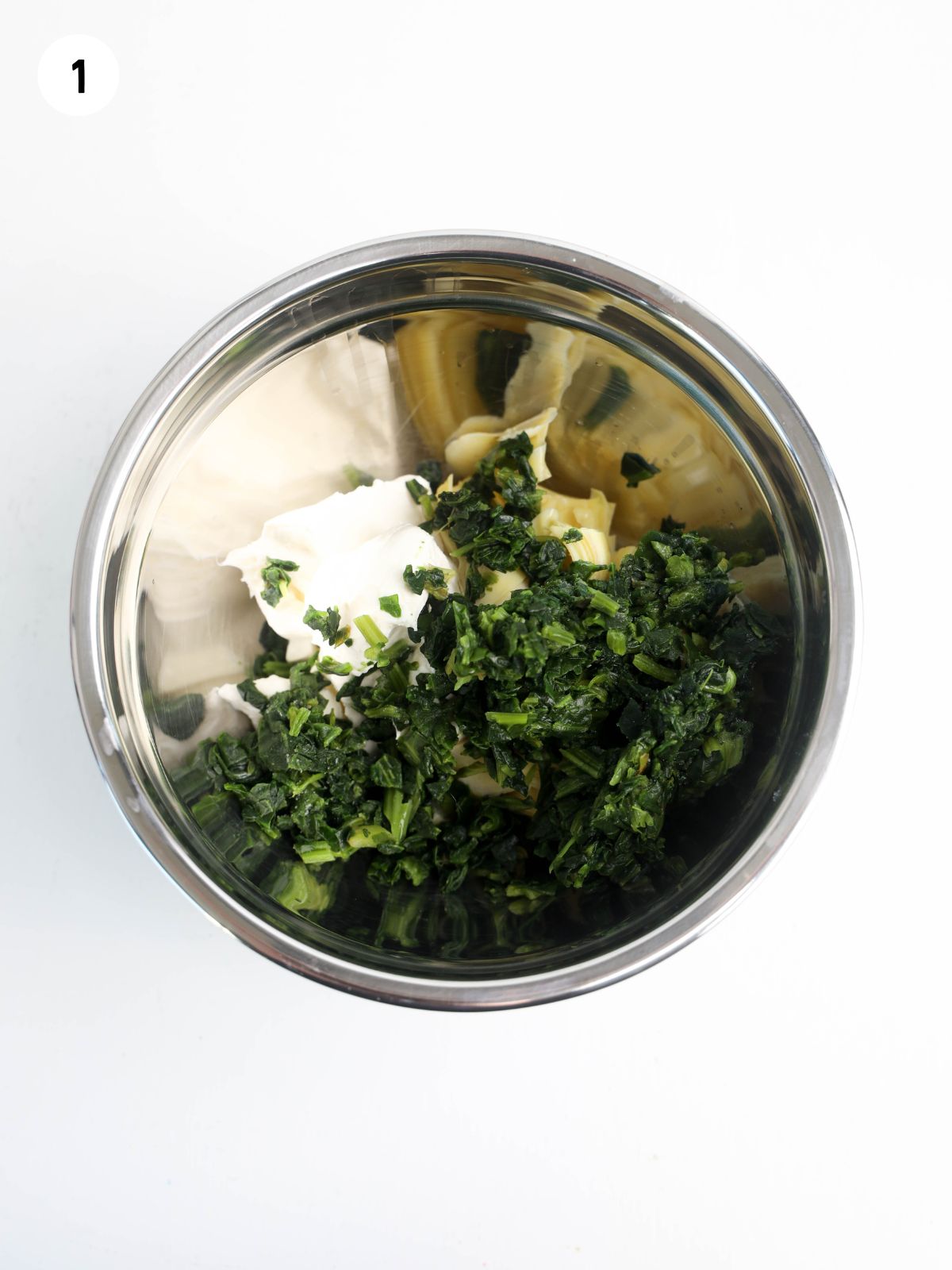 spinach, artichokes and cream cheese in metal bowl.