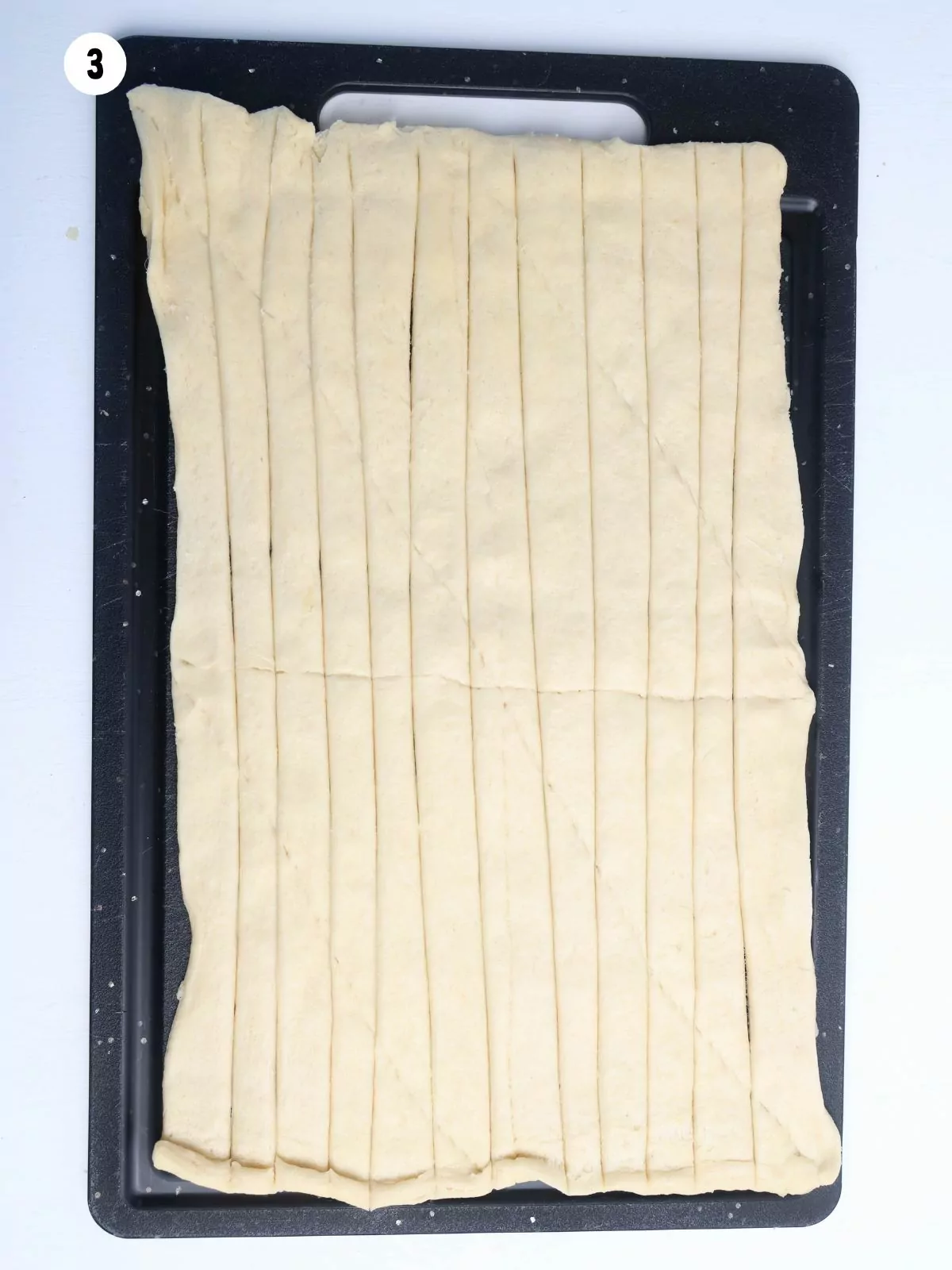 crescent roll dough sliced into strips.