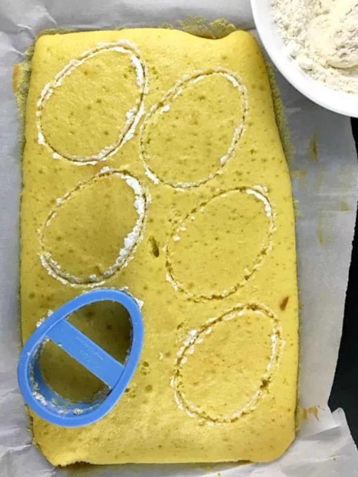 blue plastic egg cutter on top of vanilla cake.