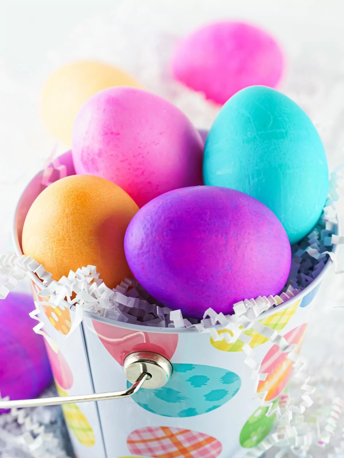 different colored Easter eggs in metal basket.