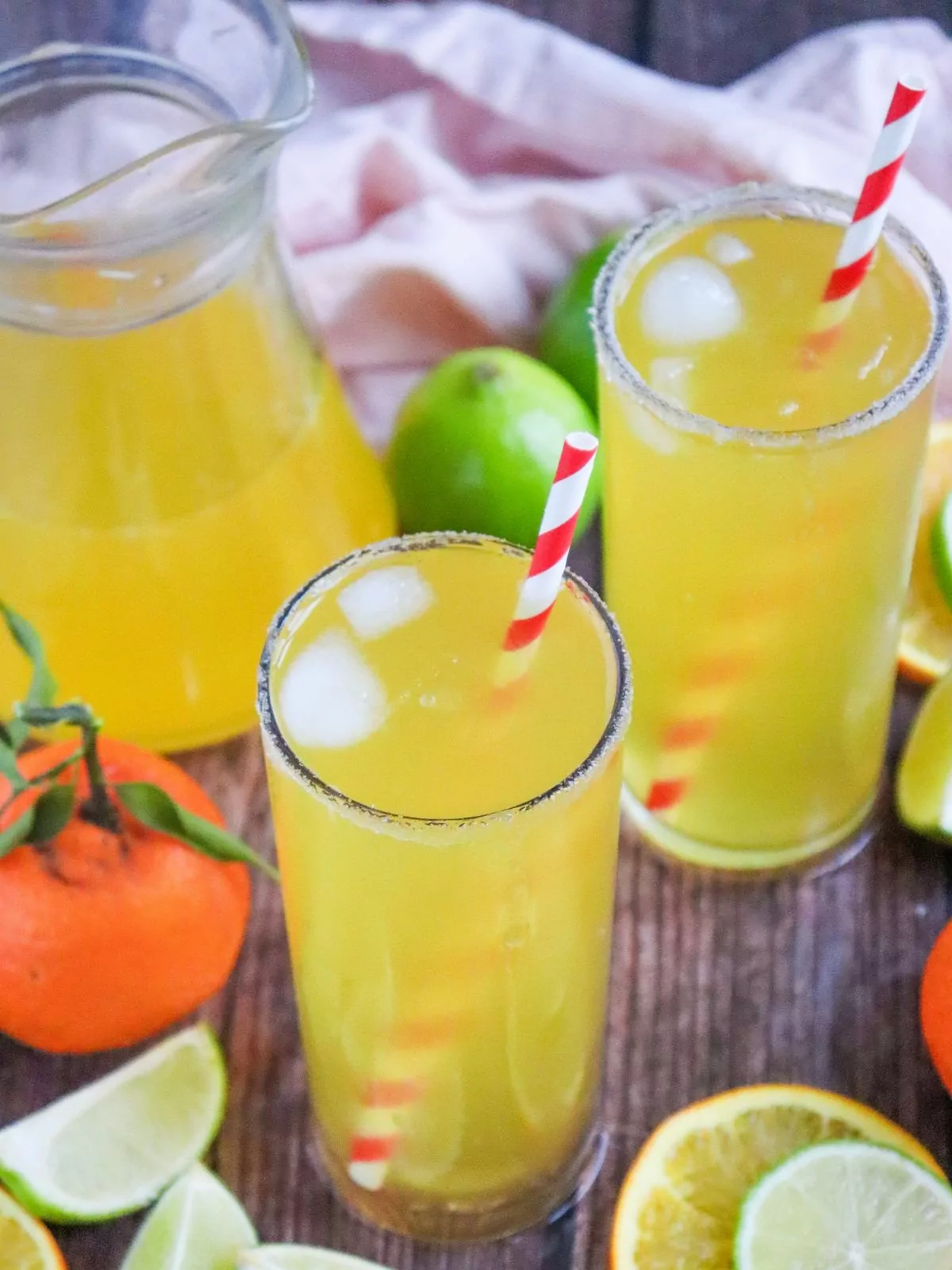 orange and lime sparkling water in glasses with straws.