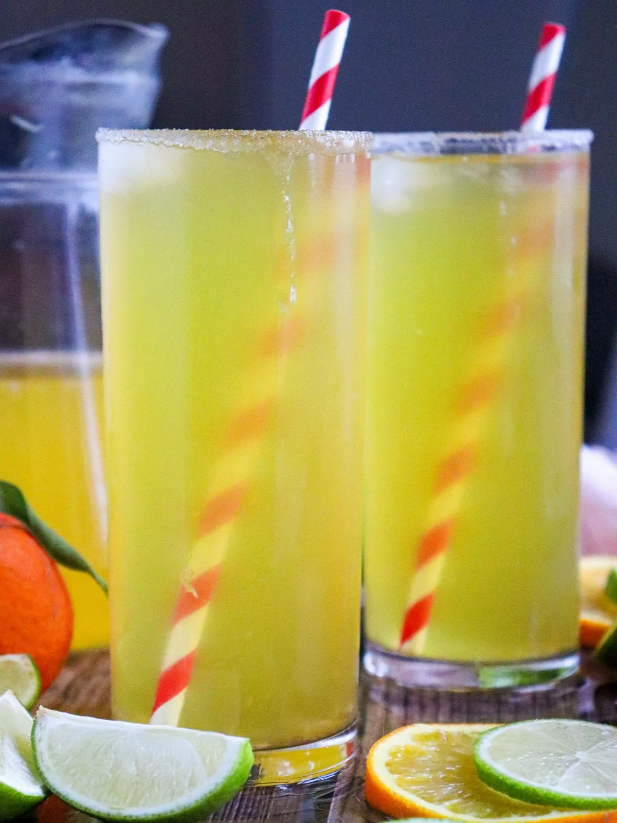 two glasses filled with lime water with orange juice.