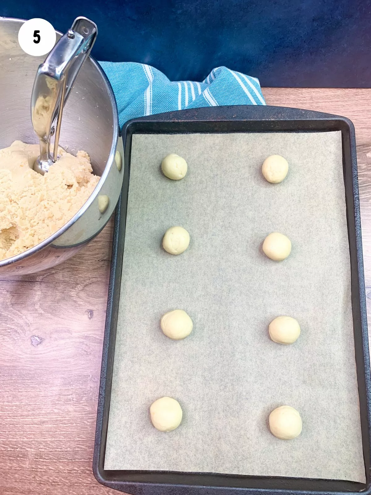 mounds of cookie dough on baking tray with parchment paper.