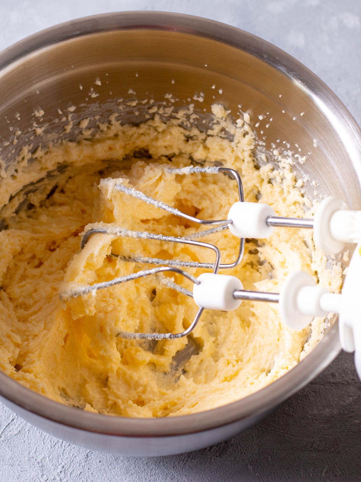 vanilla cake batter in bowl with electric beaters.