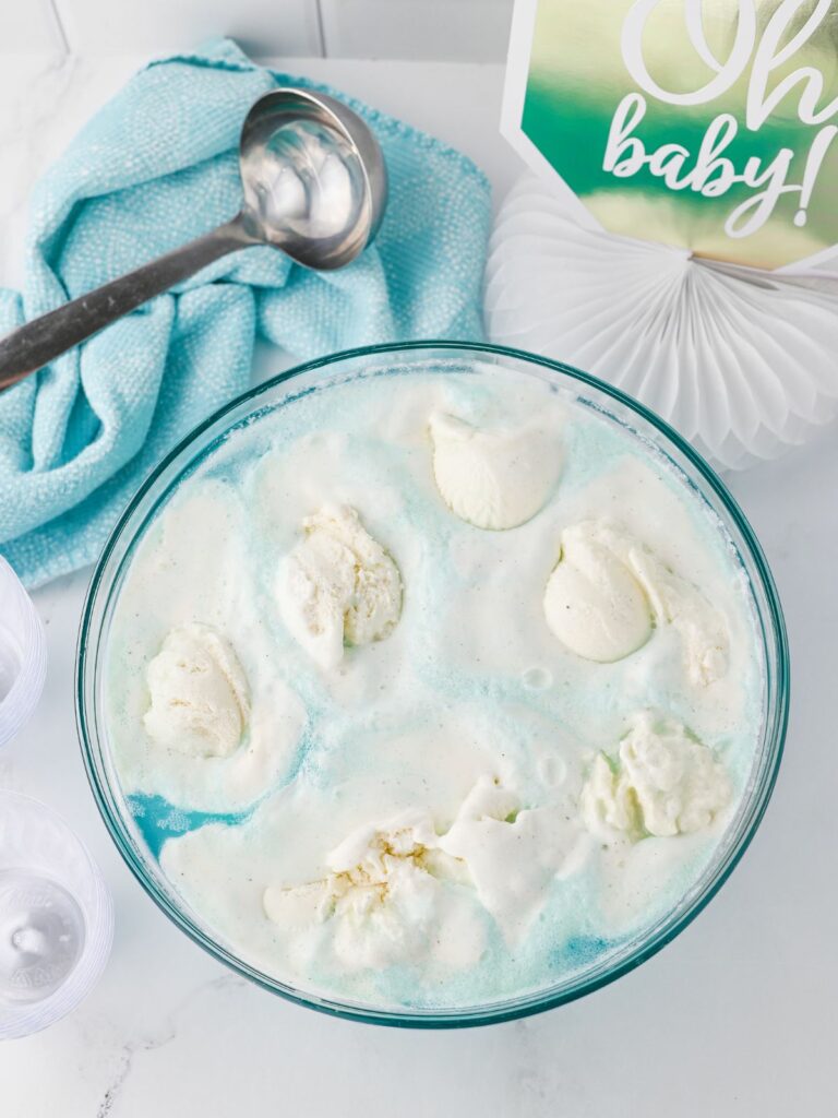 blue baby shower punch with scoops of vanilla ice cream floating on top.