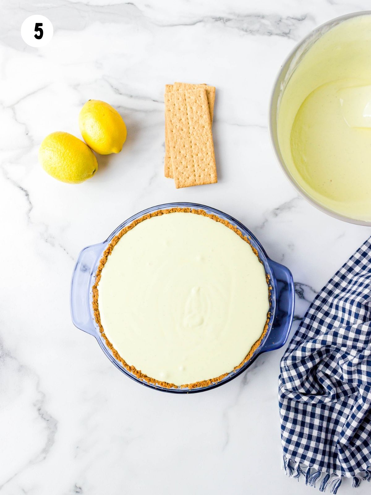 frozen lemonade pie in blue pie plate.