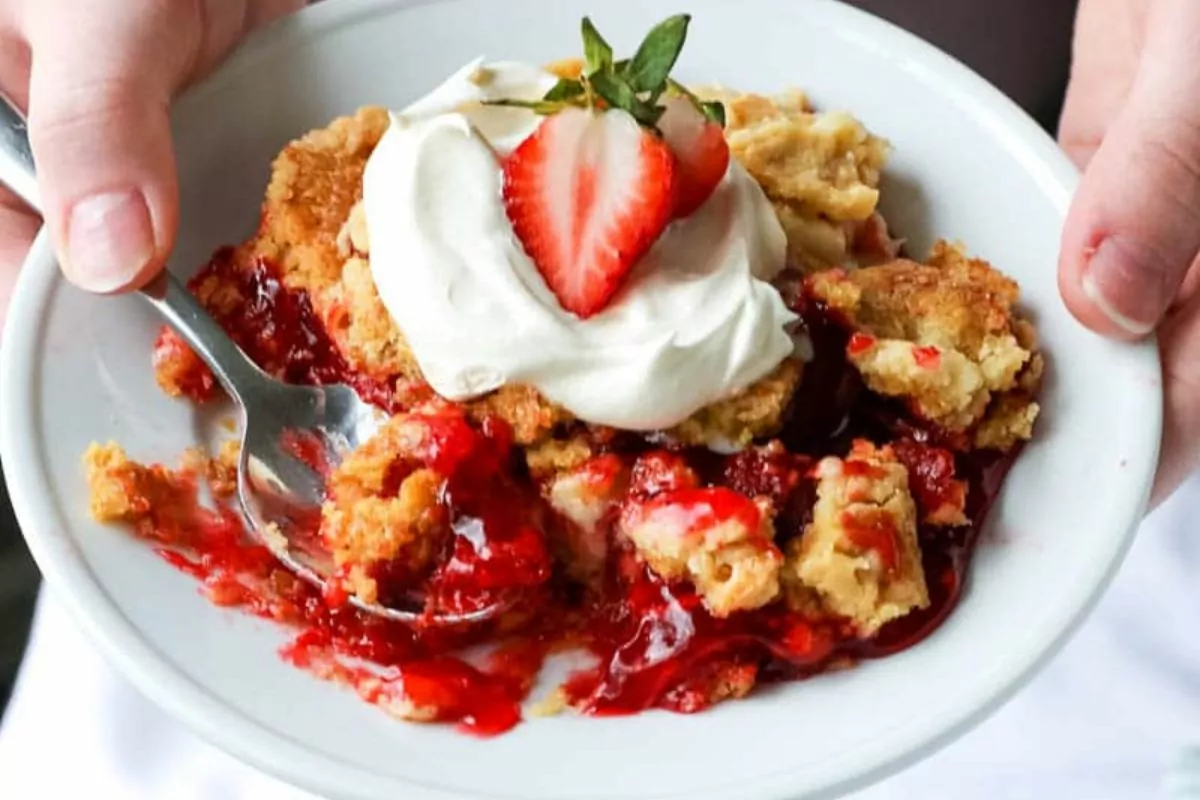 plate of Strawberry Dump Cake being held