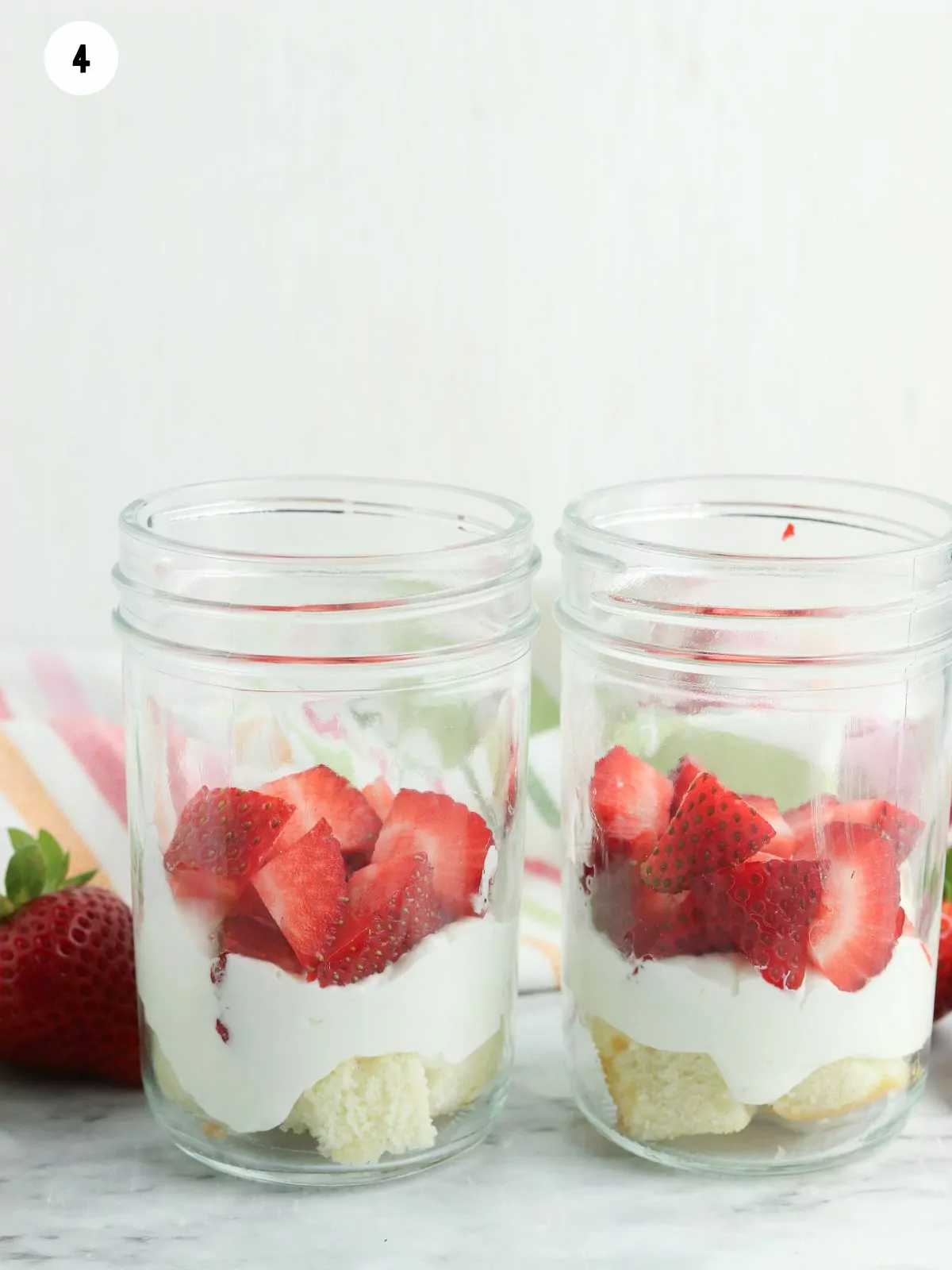 strawberry and cake in glass jars.