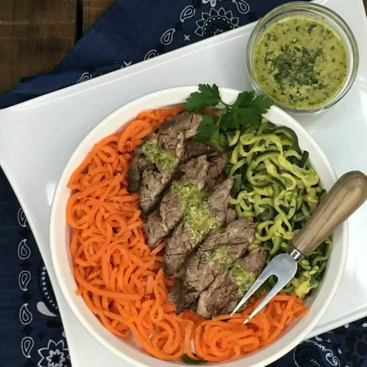 grilled steak with homemade chimichurri sauce on top of zoodles.