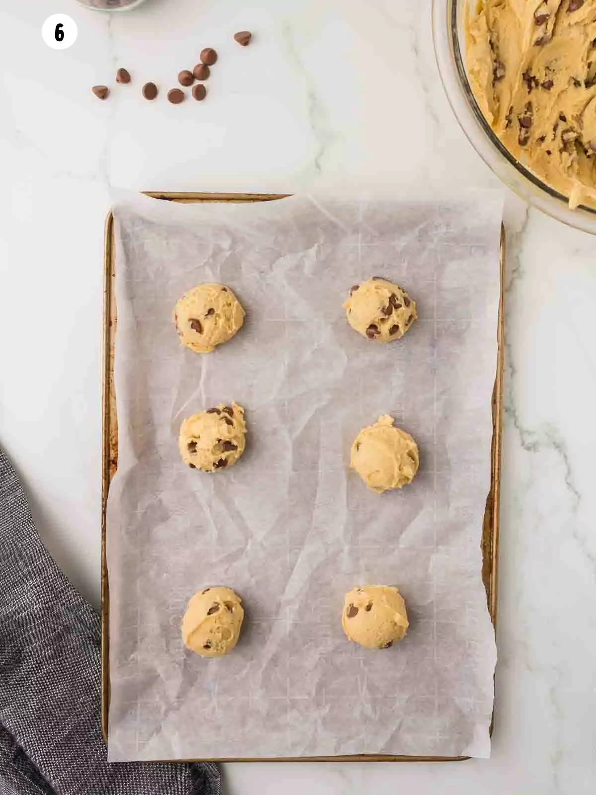 scoops of cookie dough on a parchment lined baking sheet