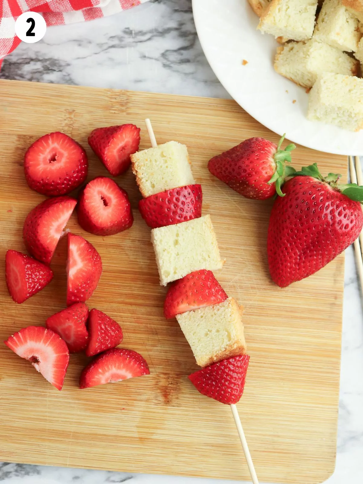 pound cake and strawberries threaded on a bamboo skewer.