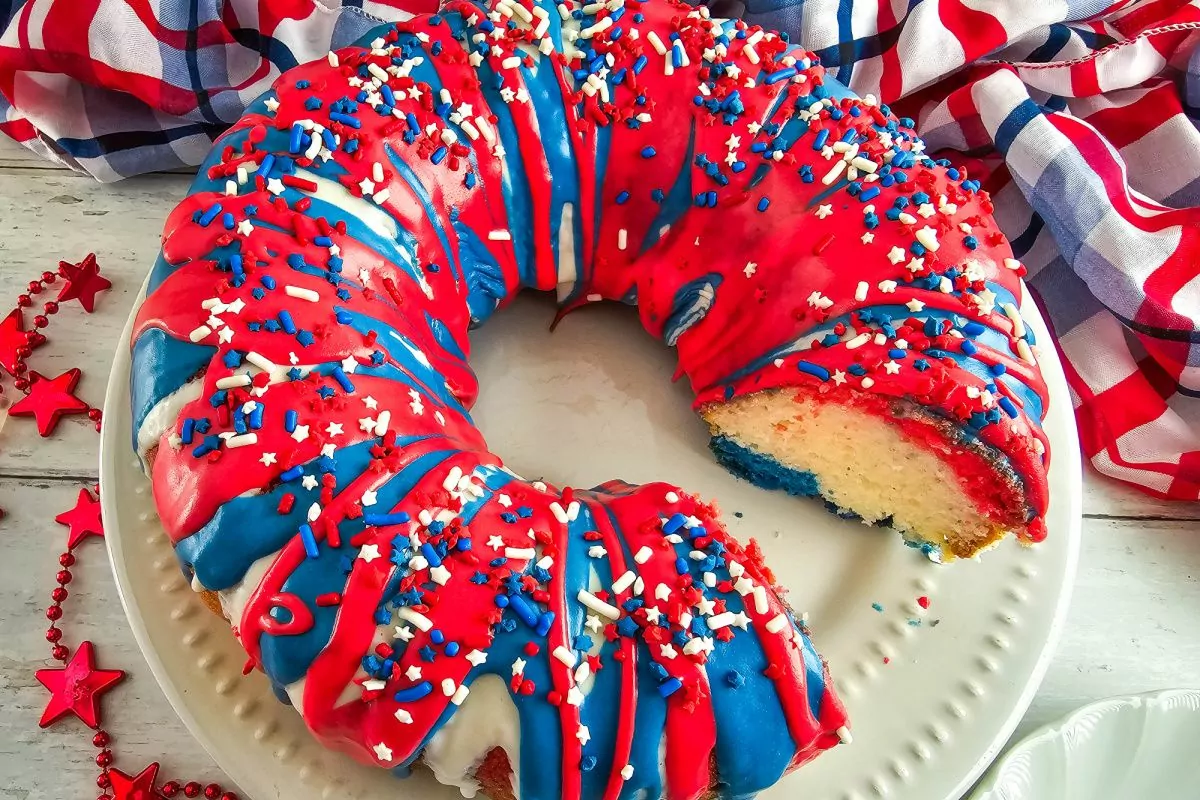 Festive 4th of July Bundt cake decorated with white frosting and patriotic sprinkles.