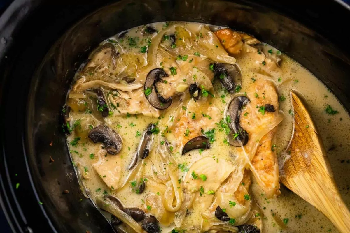 chicken cooked in crock pot with mushrooms and creamy sauce.